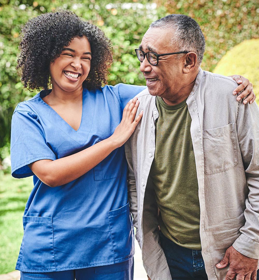 senior-man-laughing-with-his-home-caregiver-outside